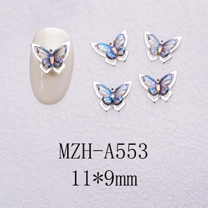 Macro detail of 11x9mm silver butterfly nail charms with iridescent translucent wings