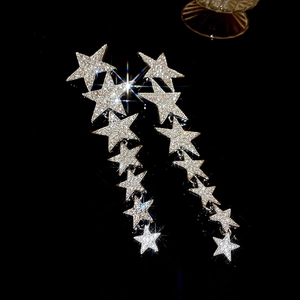 Detailed view of silver star tassel earrings with shimmering rhinestones on black background