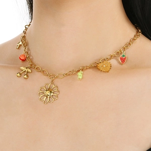Gold chain necklace with colorful resin flowers and strawberry charms on female neck