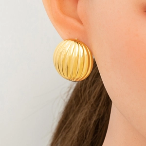 Close-up of textured 18K gold-plated star half-round earrings on a model's ear
