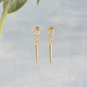 Detailed close-up of gold-plated cone earrings with S925 hallmark and sparkling zircon