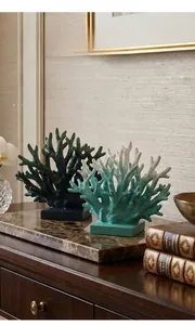 Detail of coral resin ornaments in green and teal gradient on a marble surface decor
