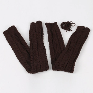 Detail of dark brown cable-knit leg warmers with matching ties on a white background