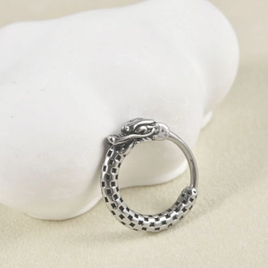 Detailed macro view of vintage silver dragon head hoop earring with intricate scale textures