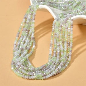Macro shot of 3mm faceted glass beads in mixed pastel colors on a white ceramic plate