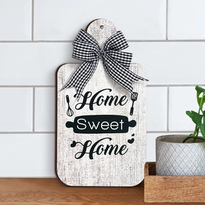 Detail of wooden kitchen sign with Home Sweet Home text and black checkered bow