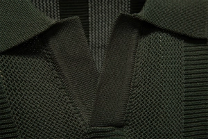 Macro shot of dark green knitted polo collar and breathable textured mesh fabric detail