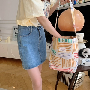 Canvas tote bag with colorful stripes shown in a casual lifestyle setting