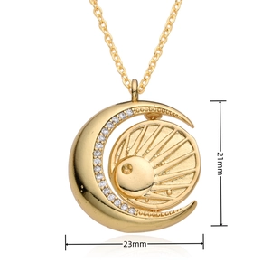 Detail view of gold sun and moon pendant with white zircon stones showing 21x23mm dimensions