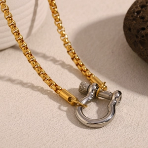 Detailed macro shot of silver U-shackle clasp on two-tone 18K gold plated box chain