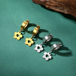 Minimalist stainless steel flower hoop earrings in gold and silver on a green surface