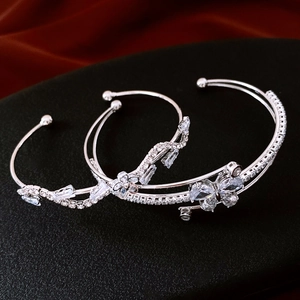 Close-up of silver zircon butterfly triple-layer cuff bracelet on dark red silk