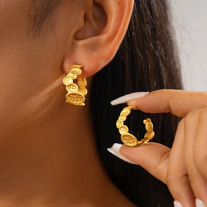 Irregular textured geometric C-shaped gold hoop earrings worn on model for a modern look