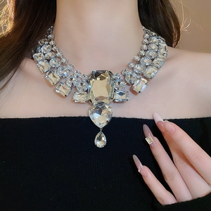 Macro shot of silver-tone statement necklace with heart and teardrop crystal pendants
