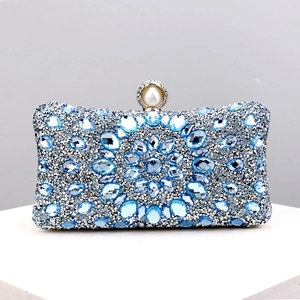 Detail of blue rhinestone evening clutch bag with elegant large pearl decorative clasp