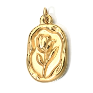 Macro detail of oval gold stainless steel pendant featuring an embossed tulip floral design