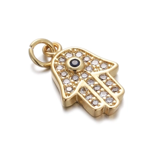 Detailed view of a golden Hamsa pendant with sparkling zircons and a blue stone eye