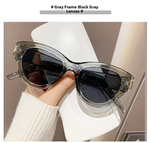 Close-up of cat-eye sunglasses with grey frames and gold metal hinge details