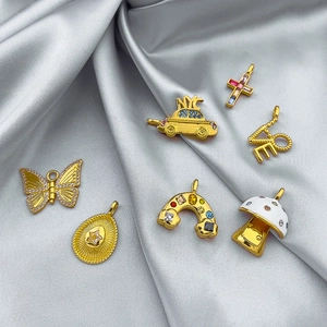 Gold Christmas pendants set with enamel and gems on silver silk background