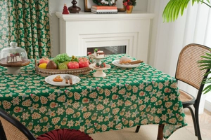 Close-up of green cotton linen tablecloth with gingerbread man and snowflake prints