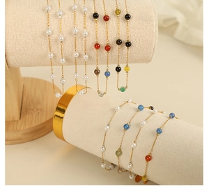 Detail of elegant pearl and multi-color stone beaded necklace with fine gold chain set