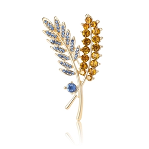 Elegant gold leaf brooch with blue and orange crystals featuring a realistic mirror reflection