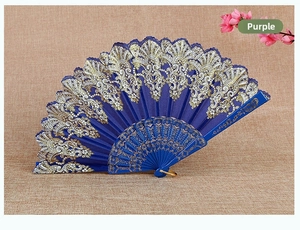 Detail of blue European folding fan with gold lace patterns and decorative carved ribs