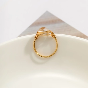 Macro detail of handmade wire wrapped gold ring with irregular light yellow crystal stone