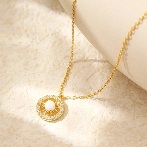 Minimalist gold s925 silver starburst necklace with opal and zircons on beige background
