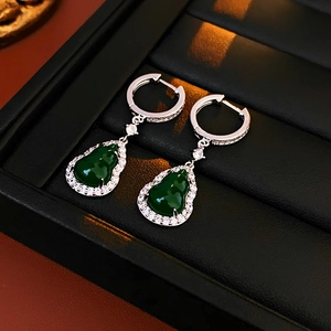 Close-up of elegant green gourd-shaped zircon pendant earrings in a black jewelry box