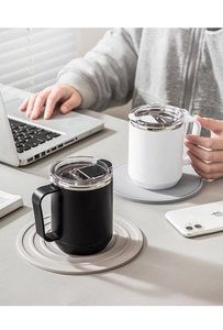 Mugs isolés en acier inoxydable noir et blanc avec couvercles dans un décor de bureau