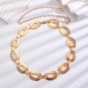 Detail of bohemian gold metal link belt featuring hollow oval segments and lobster clasp