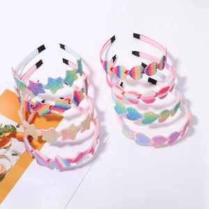 Close-up of colorful glitter star and heart headbands with rainbow gradient accents