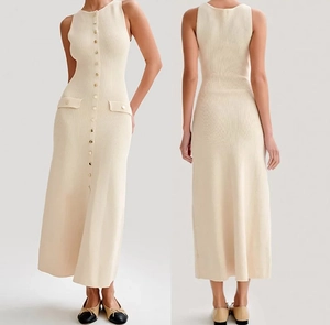 Détails d'une robe en maille beige sans manches avec boutons métalliques et poches décoratives