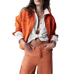 Detail of orange denim jacket and wide leg pants set with metal buttons and frayed edges