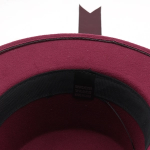 Detailed close-up of 100% polyester cloche hat interior with sweatband and care label