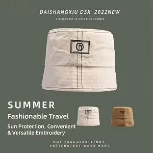 Classic canvas bucket hat with embroidered logo patch in beige and caramel brown tones