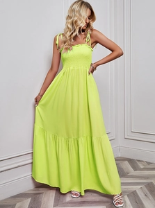 Detail of smocked elastic chest and layered tiered skirt on neon green maxi dress