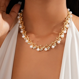Detail of vintage gold vine necklace with faux pearls and rhinestones on a model