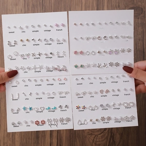 Gros plan de 50 paires de boucles d'oreilles assorties avec cœurs, étoiles et perles