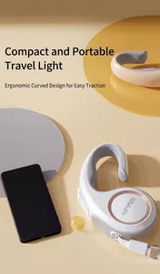 Detail of automatic retractable pet leash featuring white ring handle and metallic hooks