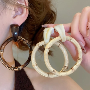 Detailed close-up of large geometric resin earrings with a natural bamboo texture