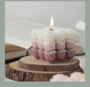 Detail of rose-shaped scented candle with purple gradient on rustic wood slice base