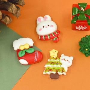 Flat lay of cute resin Christmas charms featuring bunny, sock, and cat for DIY crafts