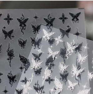 Detail of 3D embossed butterfly and star nail art stickers in black and white colors