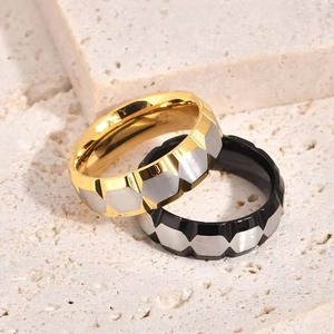 Detalle de anillo de acero de titanio bicolor con diseño geométrico de rombos