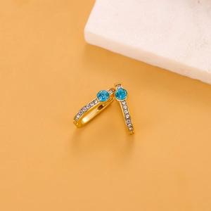 Detailed close-up of golden U-shaped earrings with sky blue stones and white zircon accents