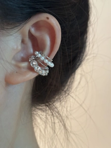 Détail macro de la manchette d'oreille argentée avec perles et oxydes de zirconium