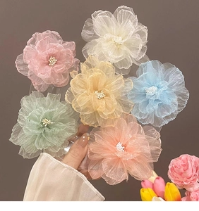 Vue détaillée de six pinces à cheveux fleurs en organza colorées aux tons pastel doux