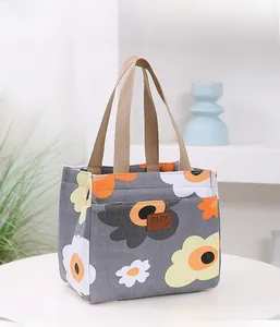 Détail du sac à lunch isotherme en oxford avec motifs floraux jaunes et étiquette en cuir